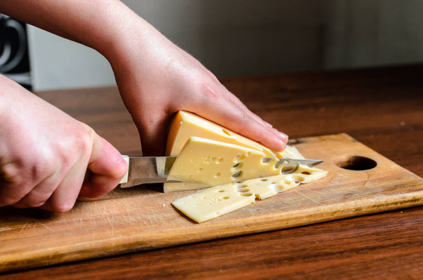 Slicing cheese on a wooden board - Foto, immagini