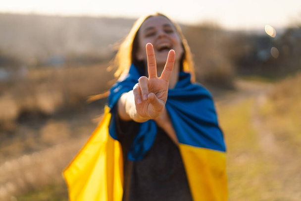 Chica ucraniana alegre que muestra un signo de paz o victoria. - Foto, imagen