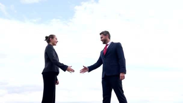 Szczęśliwa kobieta i mężczyzna partnerzy biznesowi uścisnąć dłonie na niebie, partnerstwo - Materiał filmowy, wideo