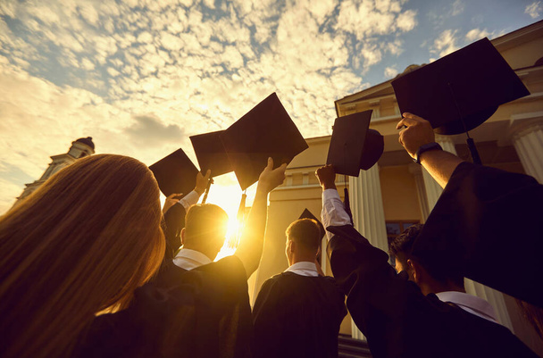 Graduates with caps at sunset - Fotó, kép