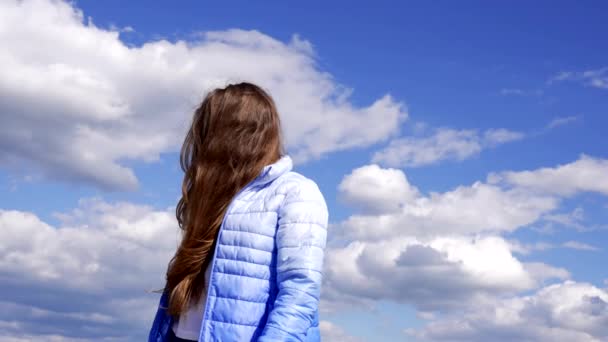 χαρούμενο παιδί με φθινοπωρινό σακάκι που δείχνει μακριά μαλλιά στο φόντο του ουρανού, ελευθερία - Πλάνα, βίντεο