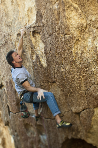 Скелястий альпініст чіпляється до крутої скелі
. - Фото, зображення