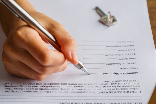 Kira sözleşmesi belge konsepti. Ev sahibi kira belgesini kalem ve anahtarla, kira sözleşmesi formuyla imzalıyor.. - Fotoğraf, Görsel