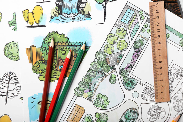 Paper sheets with sketches for landscape design and stationery on table - 写真・画像