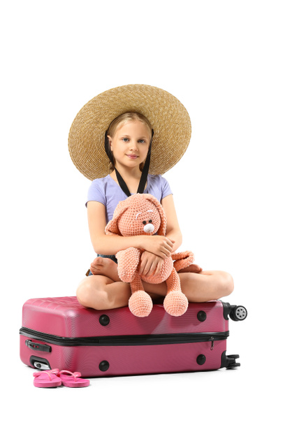 Cute little girl with suitcase and bunny toy on white background - Φωτογραφία, εικόνα