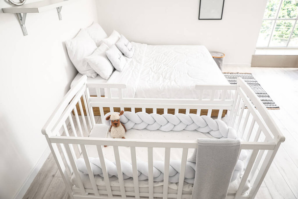 Comfortabele babybedje in het interieur van gezellige slaapkamer - Foto, afbeelding