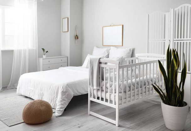 Modern belső tér hangulatos szoba nagy ággyal és kényelmes babaágy - Fotó, kép