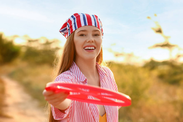 Szczęśliwa młoda kobieta z frisbee w letni dzień - Zdjęcie, obraz