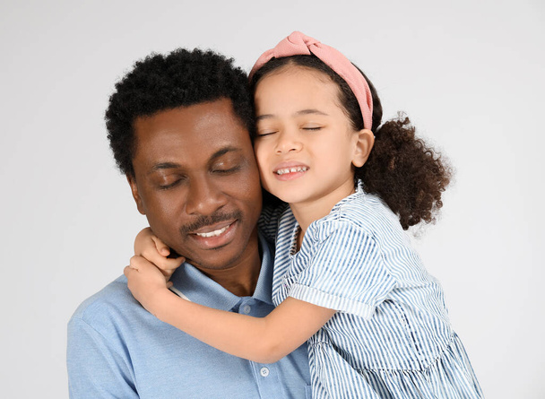 Портрет маленькой афроамериканской девочки и ее отца на сером фоне - Фото, изображение