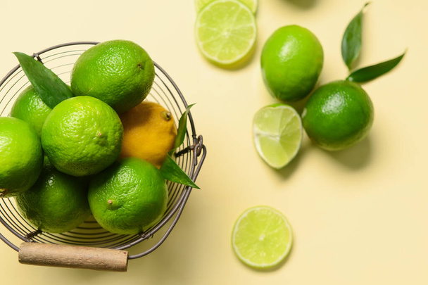 Mand met rijpe limoenen en citroen op kleur achtergrond - Foto, afbeelding