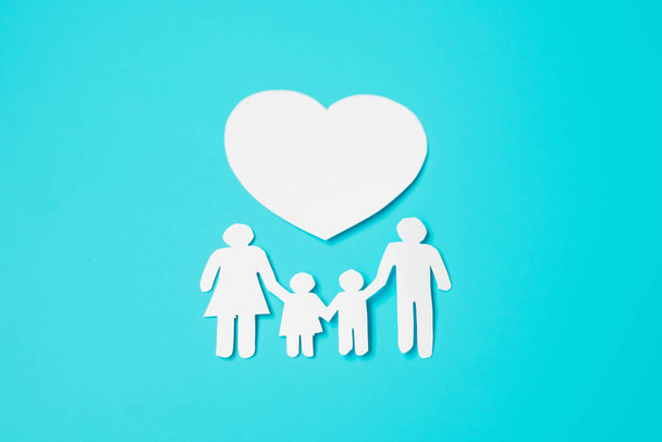 Happy Family day. Papierausschnitt mit Vater, Mutter, Kindern und Herz. Internationaler Tag der Familien, Warmes Haus, Liebe, Pflege, Versicherung, Charity und Spendenkonzepte. - Foto, Bild