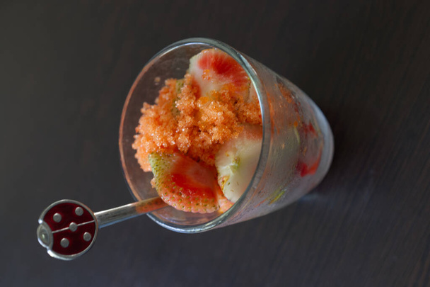 Verse aardbei met suiker, zout en chili poeder in glazen beker - Foto, afbeelding