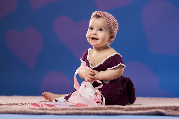 Closeup of an adorable little girl in her first year, studio shot on blue background - Фото, изображение