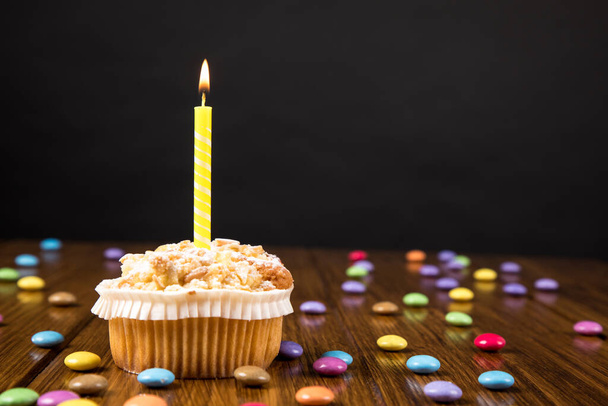 birthday cupcake with candles on wooden table - Foto, immagini