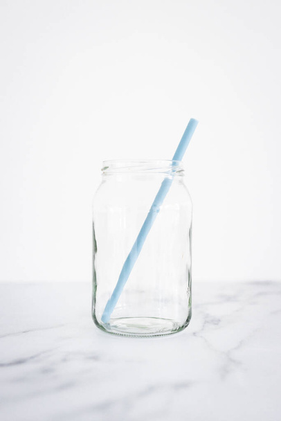 frasco de vidrio upcycled con pajitas de silicio en lugar de contenedor de plástico y pajitas, concepto de cero residuos y opciones ambientalmente conscientes - Foto, imagen
