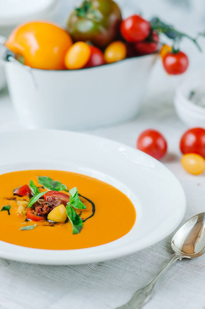 Delicious creamy tomato soup with herbs. Summer light yellow tomato soup. - Foto, Imagem