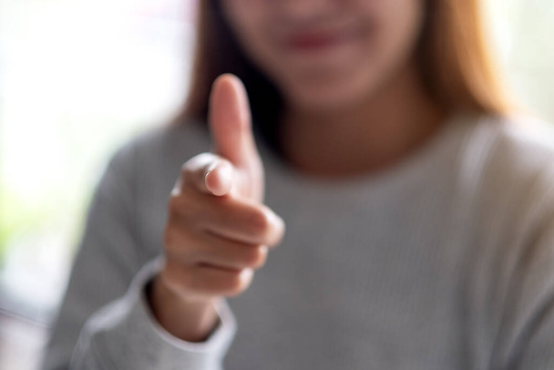 Closeup image of a young woman pointing finger at you - Photo, Image