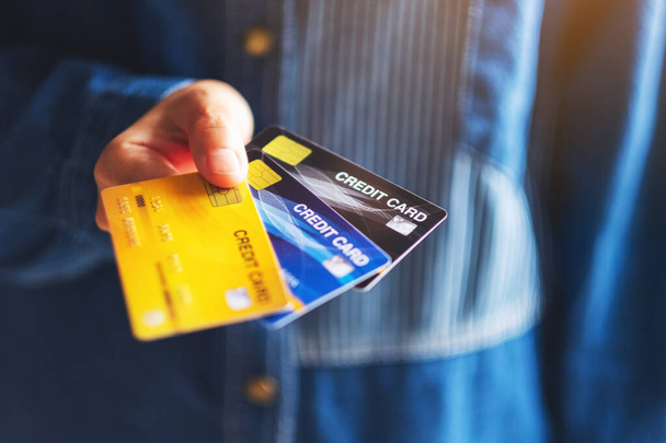 Imagen de primer plano de una mujer sosteniendo y mostrando tarjetas de crédito
 - Foto, Imagen