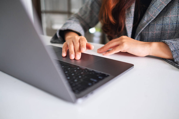 Szoros kép egy nőről, aki laptop billentyűzeten dolgozik és gépel fából készült asztalon - Fotó, kép