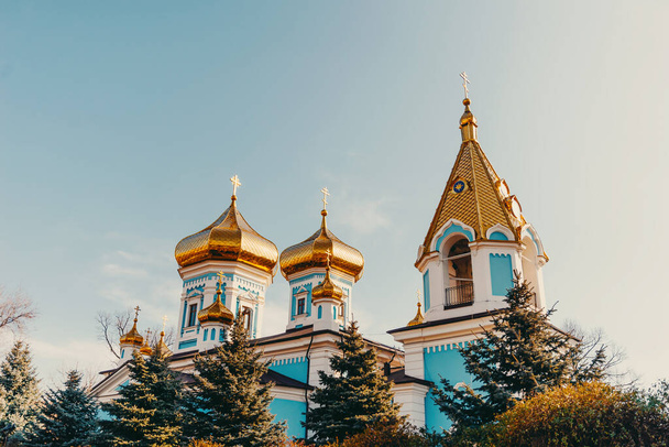 Moldova, Chisinau, 16 de febrero de 2022. Foto urbana de una iglesia ortodoxa con techo de cúpulas doradas. - Foto, imagen