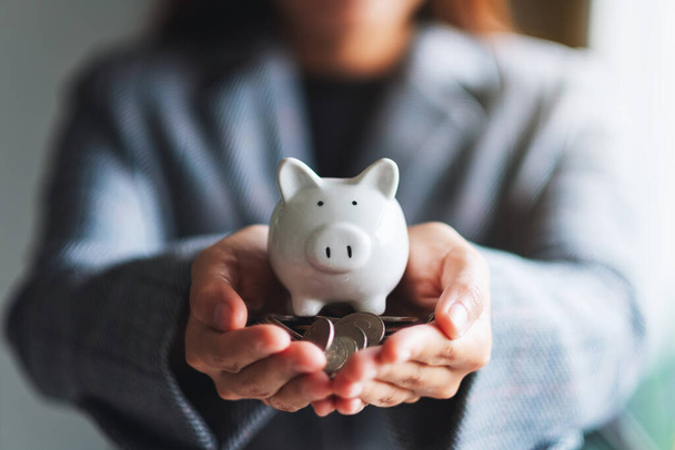 Nahaufnahme einer Frau, die Sparschwein und Münzen in Händen hält, um Geld und Finanzkonzept zu sparen - Foto, Bild