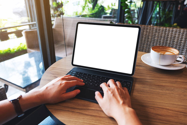 Imagen burlona de una mujer usando y escribiendo en el teclado de la tableta con la pantalla blanca en blanco del escritorio como una PC de la computadora en la tabla - Foto, imagen