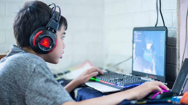 Teenage играет в компьютерную игру с наушниками - Фото, изображение