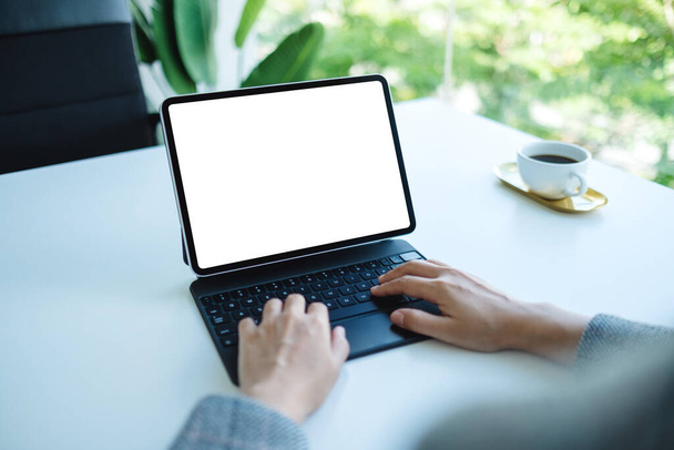 オフィスのコンピュータのPCとして空白の白いデスクトップ画面とタブレットキーボードを使用して入力する女性のモックアップイメージ - 写真・画像