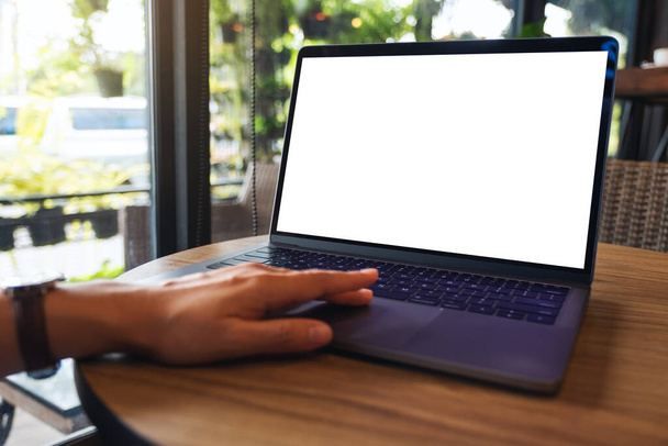 Mockup obraz kobiety za pomocą i dotykając na laptopie touchpad komputera z pustym białym ekranem pulpitu na drewnianym stole - Zdjęcie, obraz