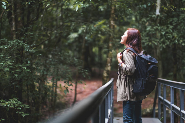 Naispuolinen matkamies reppunsa kanssa kävelee metsään - Valokuva, kuva