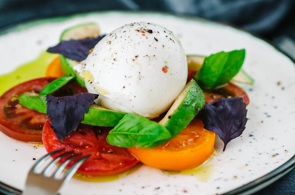 Buffalo burrata cheese served with fresh raw tomatoes and basil leaves - Foto, Imagem