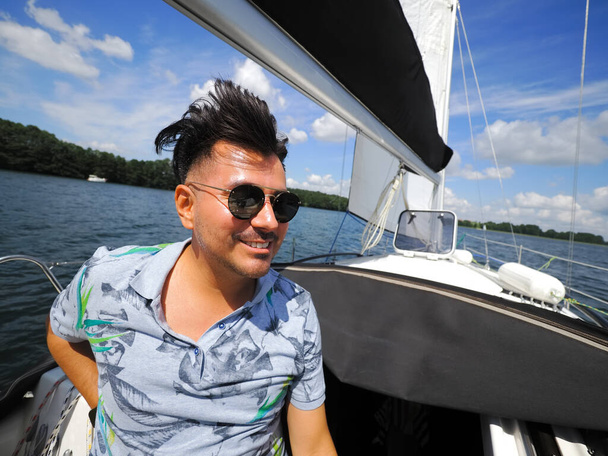 smiling one adult person on a sailboat during his yacht voyage in a sunny summer day - Foto, immagini