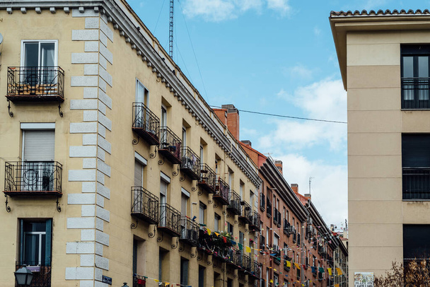 Low angle view of old residential buildings in Lavapies quarter in central Madrid - 写真・画像