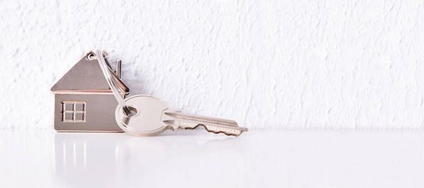 Schlüsselanhänger mit Hausschlüssel auf weißem Hintergrund - Foto, Bild
