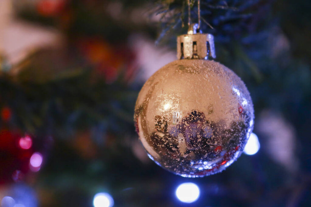 Κοντινό πλάνο ενός ασημένιου μπολ κρεμασμένου στο χριστουγεννιάτικο δέντρο, στολίδια γιορτής και Χριστουγέννων - Φωτογραφία, εικόνα