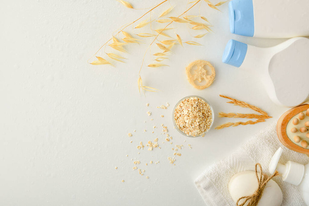 Detail of shower products with oat extract with straws and flakes on white table. Top view. Horizontal composition. - 写真・画像