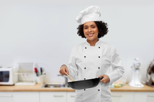 smiling female chef with frying pan in kitchen - Zdjęcie, obraz