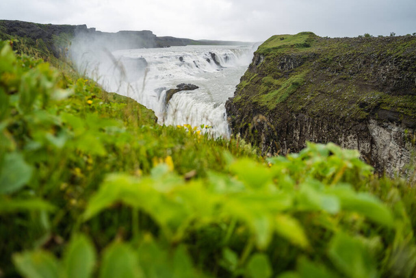 Gullfoss επίσης γνωστή ως Golden Falls καταρράκτη και πράσινο φύλλωμα σε πρώτο πλάνο. Ισλανδία. - Φωτογραφία, εικόνα