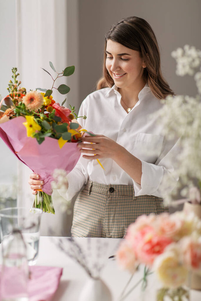 happy woman with bunch of flowers at home - Φωτογραφία, εικόνα