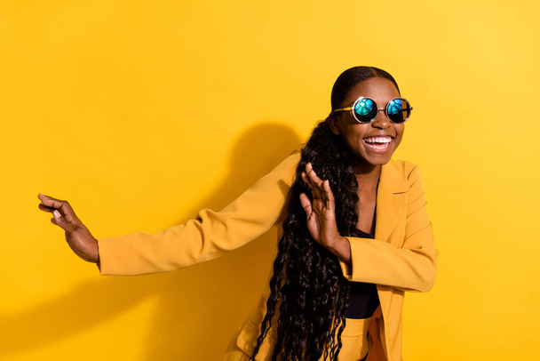 Photo of impressed millennial beauty lady dance wear glasses suit isolated on yellow color background - Фото, зображення