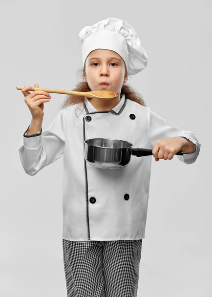 girl in chefs toque with spoon and saucepan - Valokuva, kuva