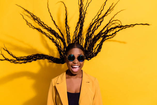 Portrait of attractive cheerful funky crazy girl hair flying good mood isolated on bright yellow color background - Foto, afbeelding