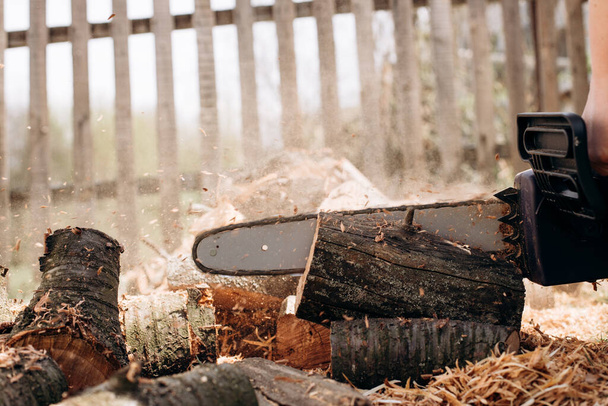 Chainsaw close up. Chainsaw with a tool. Chainsaw on the background of firewood - Φωτογραφία, εικόνα