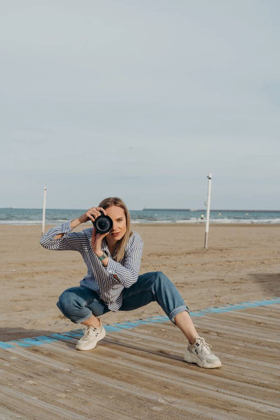 woman photographer on the beach with camera - Valokuva, kuva