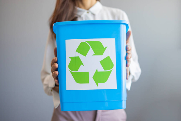 Activist taking care of environment during sorting waste to proper recycling bin at home. Separating waste to save resources. Close Up Of Woman Carrying Recycling Bin  - Foto, imagen