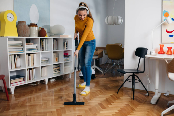 woman using vacuum cleaner at home - Valokuva, kuva
