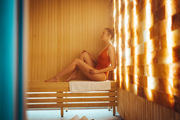 One woman relaxing in salt room and enjoying in halotherapy treatment. Beautiful woman inhales salt air, halotherapy. Salt air treatment at the spa - Fotoğraf, Görsel