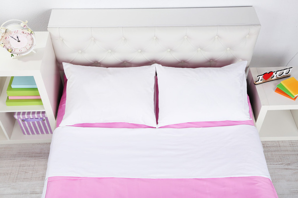 Bed in pink bed linen in room - Fotoğraf, Görsel