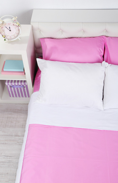 Bed in pink bed linen in room - Φωτογραφία, εικόνα