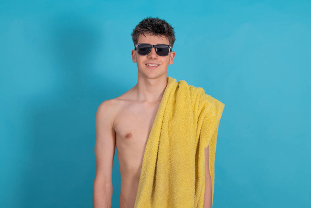 teen boy with sunglasses and beach or pool towel isolated on background - Photo, image